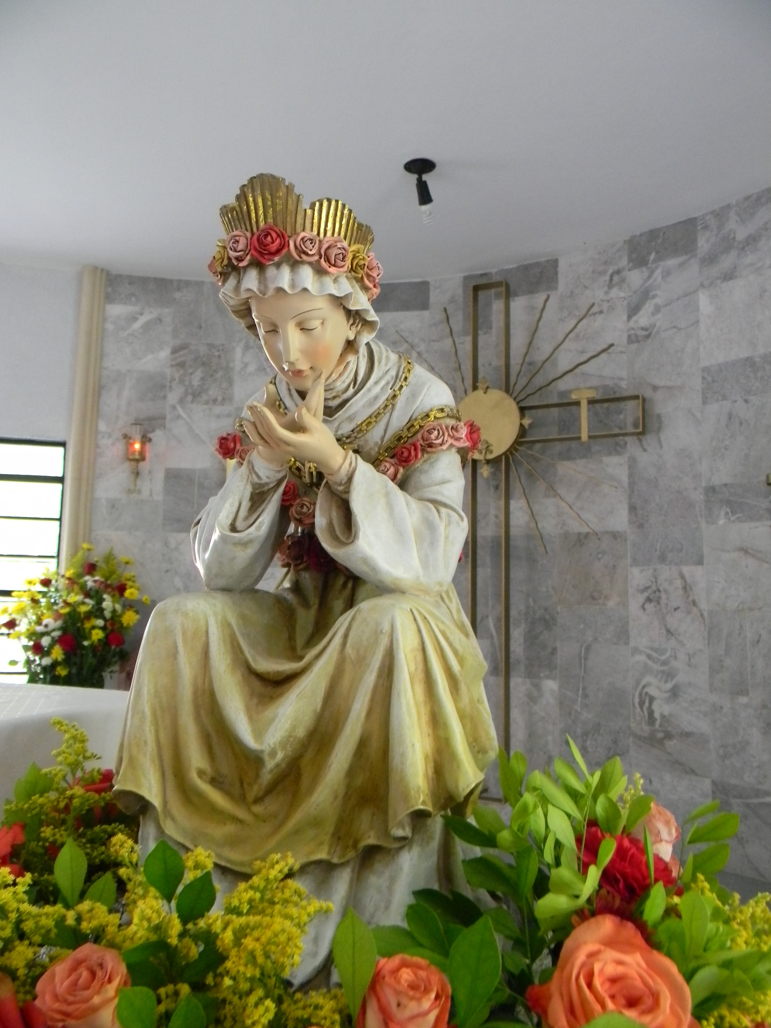 Imagen de la Virgen con una corona de rosas en la capilla